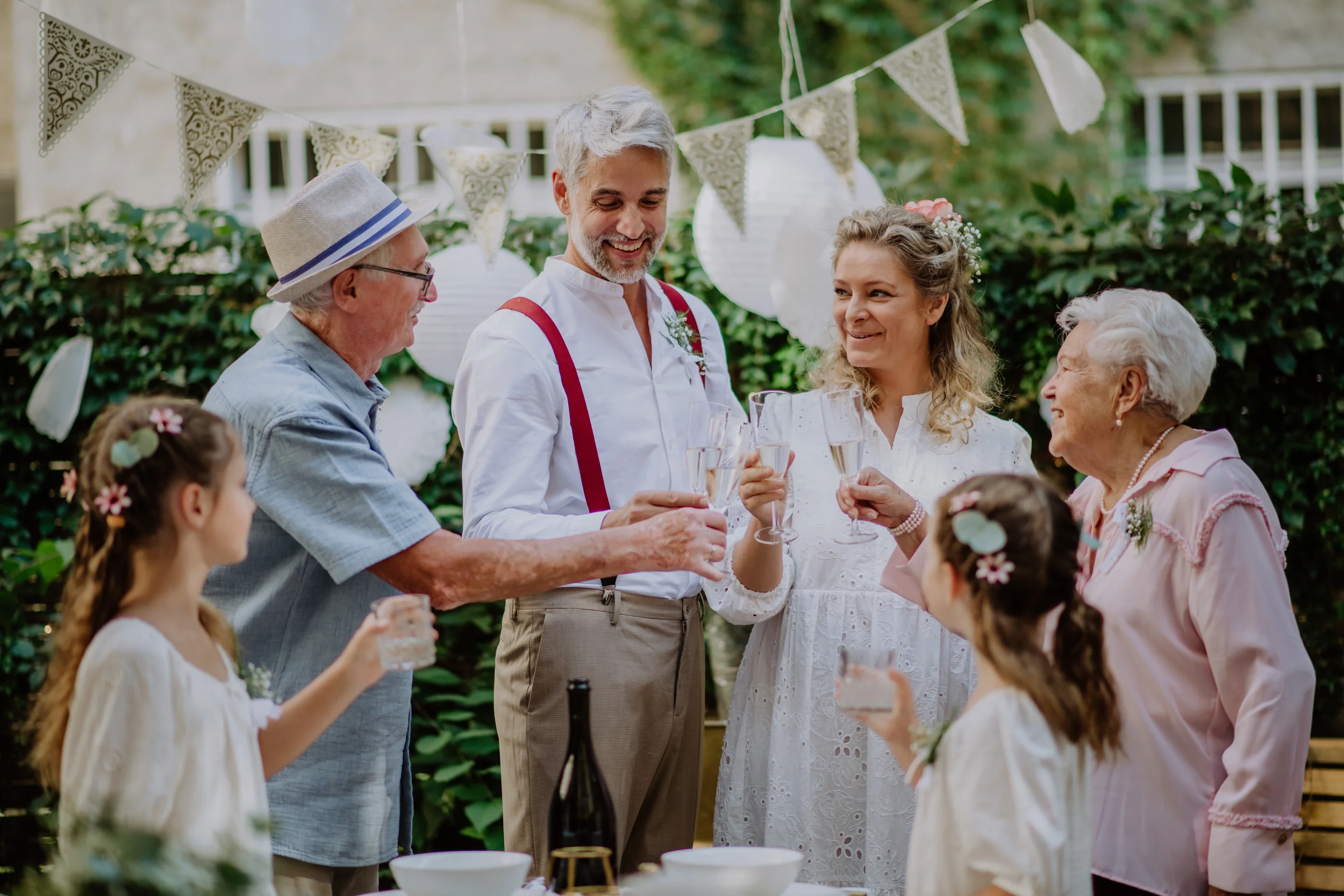 family raise glasses together in a backyard