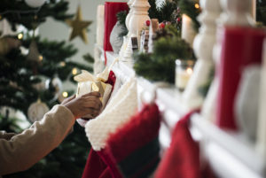 Woman putting gift into Christmas stocking